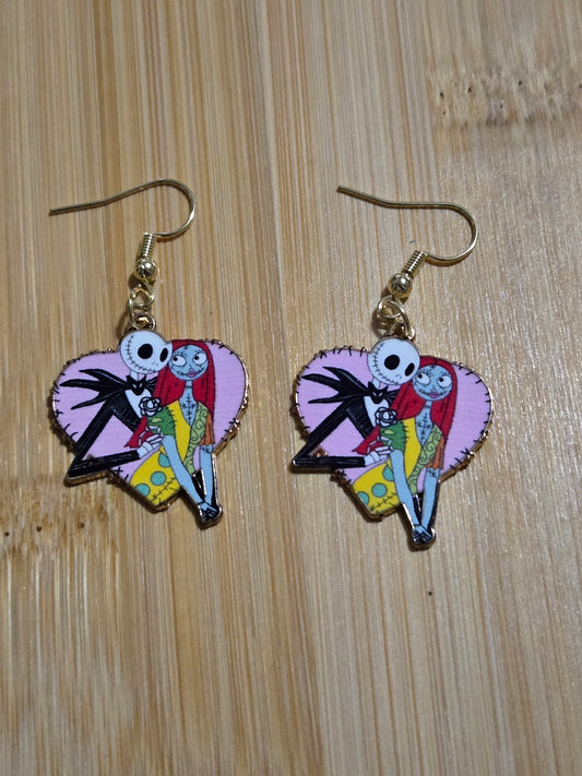A pair of earrings featuring a cartoonish design with pink hearts and characters Jack and Sally.