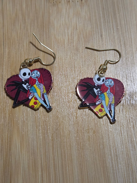 A pair of earrings featuring a red heart with the characters Jack and Sally from a popular animated movie.