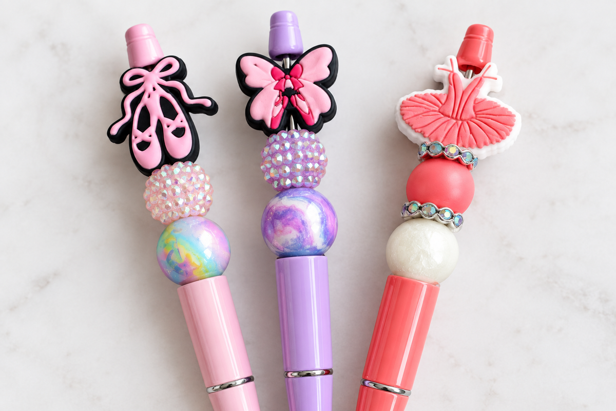 "Close-up of handmade decorative beaded pens with chunky beads and charm toppers"